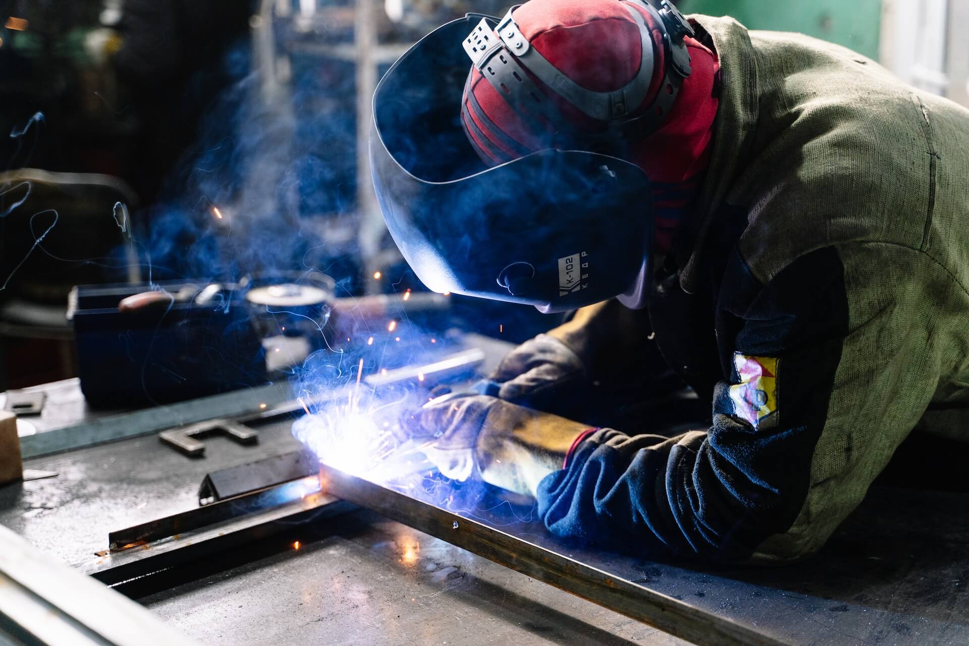 Welder working on metal in factory